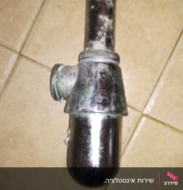 צינור מתכת חלוד על רצפת קרמיקה